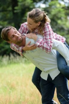 man giving lady a piggyback in the countryside