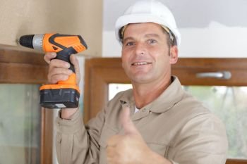 a happy construction worker assembles a window