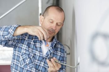 middle-age male electrician wiring a new build