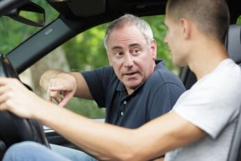 dad teaching his son to drive a car