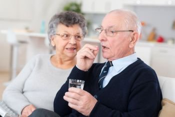 senior man taking medicament with wife