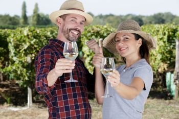 woman and man in vineyard drinking wine