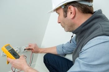 portrait of electrician installing wall socket