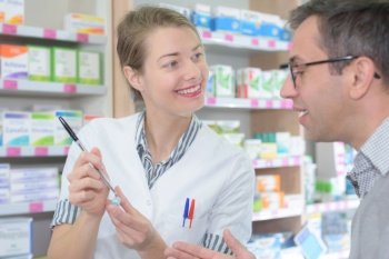 female pharmacist counseling customer about drugs usage in modern farmacy