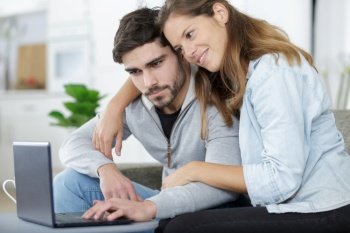 happy couple at home using a computer