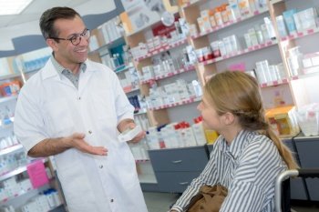 male chemist explaining product-details to customer in pharmacy