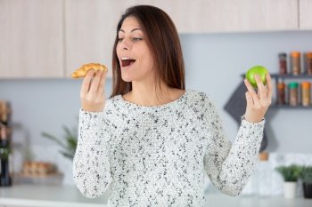 young woman choosing between donut and green apple