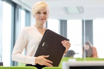 Portrait of mature businesswoman holding file in office