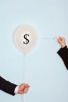 Businessman popping balloon with US Dollar sign