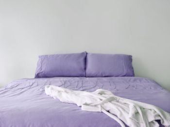 Photo of purple bed with bathrobe