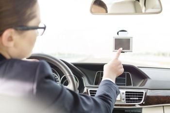 Executive using GPS navigation inside car 