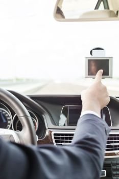 Executive using GPS navigation inside car 