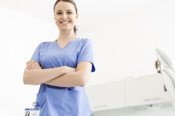 Portrait of confident smiling nurse with arms crossed at clinic