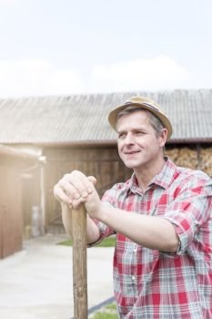 Thoughtful smiling farmer wearing hat at farm