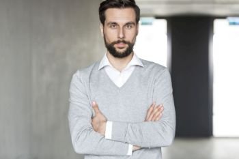 Portrait of confident businessman with arms crossed at office