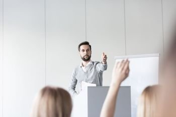 Confident businessman answering question to colleagues in conference