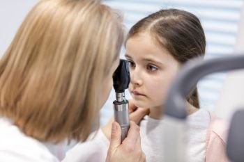 Doctor examining girl eye at hospital