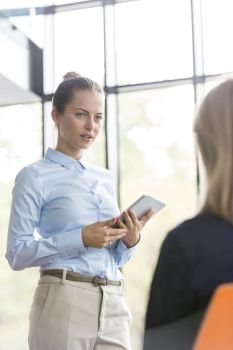 Businesswoman looking at colleague during meeting in office