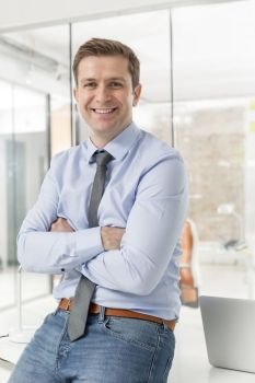 Portrait of businessman with arms crossed in office