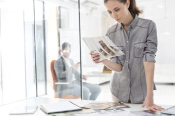 Creative businesswoman looking at photograph in office