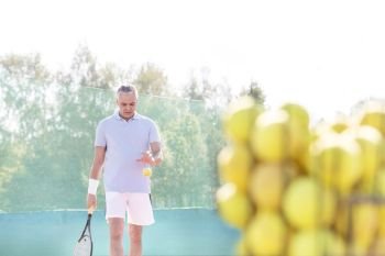 Mature man playing tennis against clear sky on sunny day