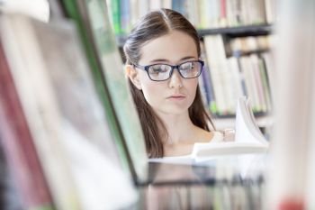 Closeup of woman reading book at library in university
