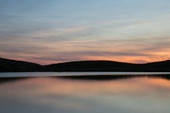 Beautiful Summer sunrise landscape of colors reflected in Llyn Cwm Lwch in Brecon Beacons National Park