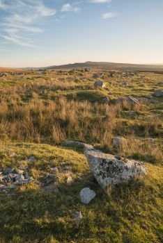 Beautiful landscape sunset image over abandoned Foggintor Quarry in Dartmoor with raking soft sunlight over ruins and derelict buildings