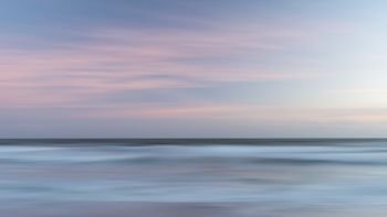 Beautiful colorful landscape image of blurred waves at sunset in Devon Enlgand