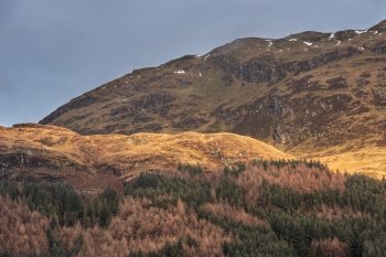 Beautiful landscape image across Loch Lomond looking towards snow capped Ben Lui mountain peak in Scottish Highlands