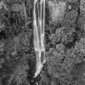Black and white Aerial flying drone Beautiful long exposure landscape early Autumn image of Pistyll Rhaeader waterfall in Wales