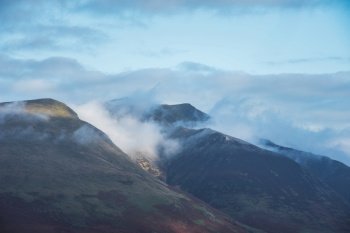 Beautiful landscape image of Blencathra covered in low cloud fog and mist viewed from Walla Crag in Lake District