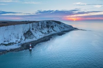 Beautiful Summer sunrise landscape image of Beachy Head Lighthouse in South Downs National Park in England