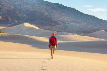 Hiker among sand dunes in the desert