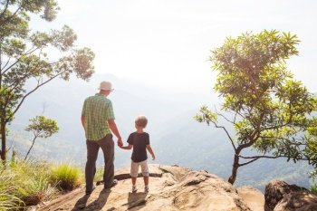 Father and son  on the cliff in Sri Lanka mountains. Happy vacation scene