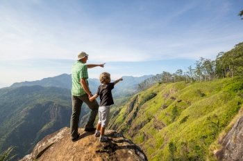 Father and son  on the cliff in Sri Lanka mountains. Happy vacation scene