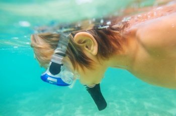 The snorkeling boy at coral reef on Sri Lanka