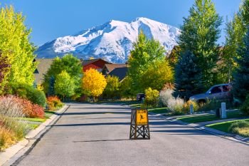 Slow children at play street sign at residential neighborhood in Colorado at autumn, USA. Mount Sopris landscape.