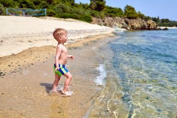 Two year old toddler boy on beach 