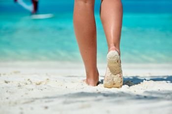 Woman walking on tropical white sand beach. Summer vacation at Maldives.