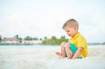 Three year old toddler boy on beach. Summer family vacation at Maldives.