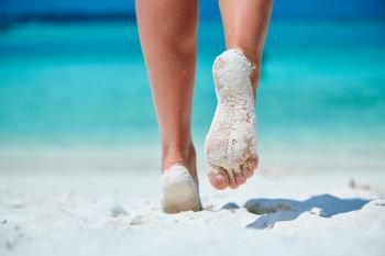 Woman walking on tropical white sand beach. Summer vacation at Maldives.