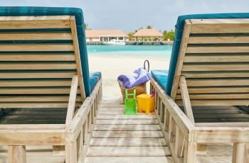 Tropical beach with wooden loungers. Summer vacation at Maldives.