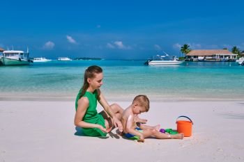 Woman applying sun screen protection lotion on boy’s back. Summer vacation at Maldives.