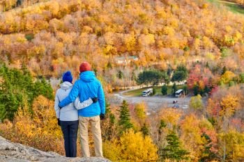 Couple hiking at Artist’s Bluff in autumn. Fall colours in Franconia Notch State Park. White Mountain National Forest, New Hampshire, USA