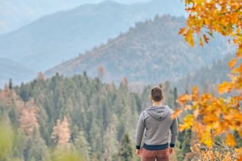 Tourist man hiking in Sequoia National Park at fall, looking at autumn mountain scenic landscape. California, United States.