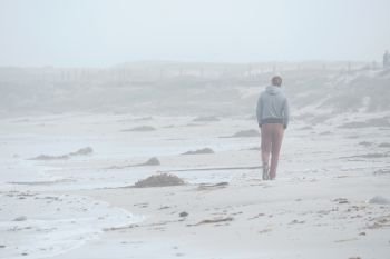 Lone man at beach, foggy autumn day. USA Pacific coast landscape, California