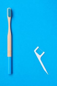 Toothbrushes and oral care tools over blue background top view copy space flat lay. Tooth care, dental hygiene and health concept. 