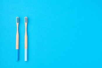 Toothbrushes on blue background top view copy space. Tooth care, dental hygiene and health concept. 