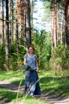 Red-haired women walking on path in the wood.